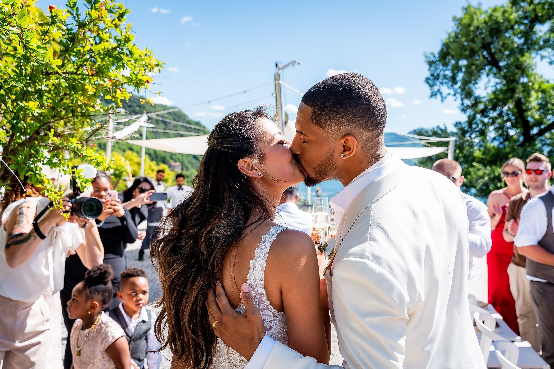 A kiss after the ceremony, guests around them