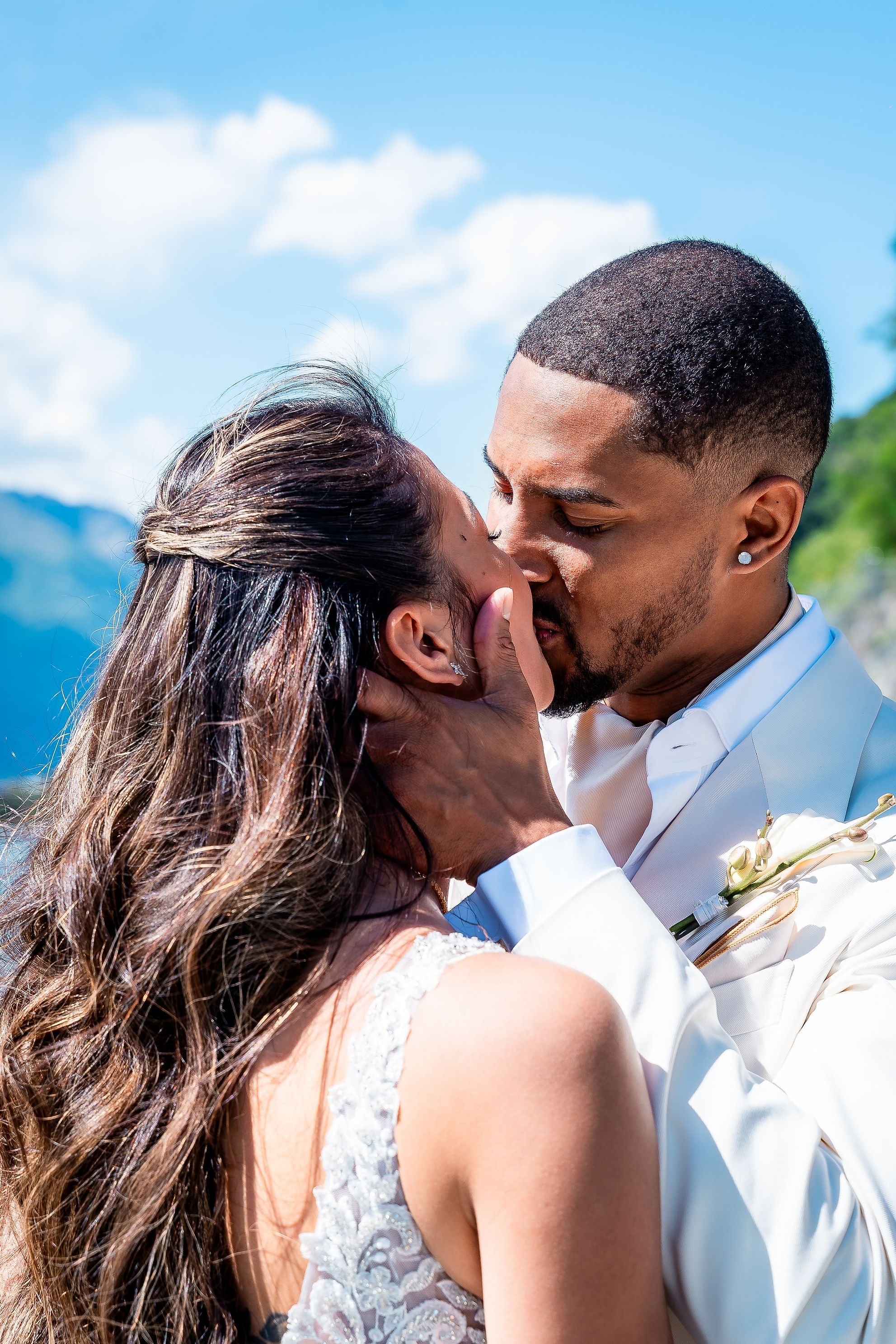 Sarina and Joshua kissing against the mountains